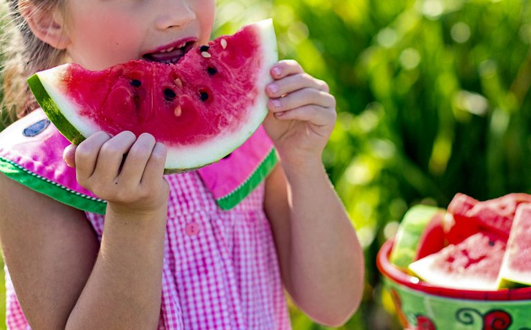 young girl eating watermelon slice