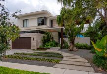 A Tropical Zen Retreat: Where Nature and Serenity Unite View of a modern tropical home from the street in a residential canal development in Miami, Florida.